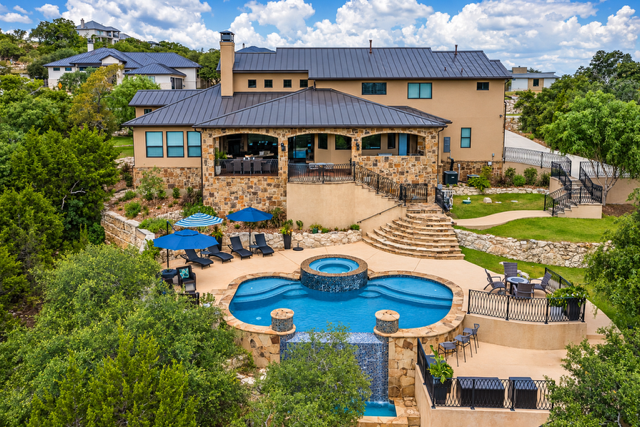 Custom home with a backyard pool and outdoor living area in The Canyons at Scenic Loop in San Antonio 